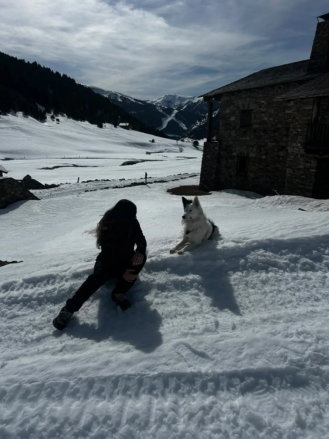 Perro blanco tumbado en la nieve junto a Ainhoa